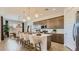 A modern kitchen features a kitchen island with seating, an open dining area and stainless steel appliances at 16933 W Bronco Trl, Surprise, AZ 85387