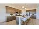 An open kitchen has gray cabinets, a kitchen island with seating, and stainless steel appliances at 16933 W Bronco Trl, Surprise, AZ 85387