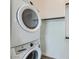 Laundry area featuring a stackable washer and dryer with storage space at 16933 W Bronco Trl, Surprise, AZ 85387