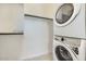 Brightly lit laundry room with a stacked washer and dryer unit at 16933 W Bronco Trl, Surprise, AZ 85387