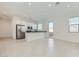 Open-concept living space featuring tile flooring and a kitchen with stainless steel appliances at 16933 W Bronco Trl, Surprise, AZ 85387