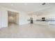 Bright, open-concept living room featuring tile floors and views into the kitchen area at 16933 W Bronco Trl, Surprise, AZ 85387