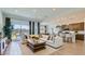 A combined space with a sectional couch, coffee table, dining area, kitchen, and ample natural light at 16933 W Bronco Trl, Surprise, AZ 85387