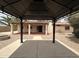 Backyard view showcasing a covered patio and desert landscaping at 2209 W Los Arboles Pl, Chandler, AZ 85224