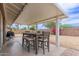 Covered patio with table, seating, and backyard landscaping with gravel and bougainvillea at 2821 E Larkspur Dr, Phoenix, AZ 85032