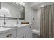 Bright bathroom featuring a large mirror, white vanity, and a shower with a marble-like tiled wall at 2821 E Larkspur Dr, Phoenix, AZ 85032