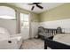 Cozy Bedroom featuring wainscotting, a ceiling fan, a comfortable chair and a crib at 2821 E Larkspur Dr, Phoenix, AZ 85032