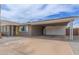 Home featuring a covered parking area, desert landscaping, and modern yellow front door at 2821 E Larkspur Dr, Phoenix, AZ 85032