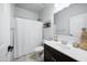 Well-lit bathroom featuring a shower with a curtain, a vanity with storage, and neutral wall paint at 31051 W Amelia Ave, Buckeye, AZ 85396