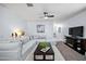 Cozy living room with plush sectional sofa, ceiling fan, and modern entertainment center at 31051 W Amelia Ave, Buckeye, AZ 85396