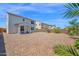 Large backyard featuring a covered patio with view of the home's exterior and lush desert landscape at 32347 N Vernal Ln, San Tan Valley, AZ 85144