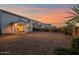 Backyard at sunset featuring a covered patio with view of the home's exterior and lush desert landscape at 32347 N Vernal Ln, San Tan Valley, AZ 85144