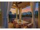 Relaxing outdoor covered patio with stylish furniture and a serene view of the sunset and backyard at 32347 N Vernal Ln, San Tan Valley, AZ 85144