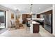 Modern kitchen boasts dark wood cabinetry, granite counters, stainless steel appliances, island with barstool seating, and a breakfast nook at 32347 N Vernal Ln, San Tan Valley, AZ 85144