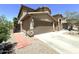 Side view of home shows the two-car garage, brick pathway, and desert landscaping at 33506 N 24Th Dr, Phoenix, AZ 85085
