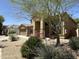Home showcasing an arched entryway, desert landscaping, and mature shade tree at 33506 N 24Th Dr, Phoenix, AZ 85085