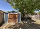 Backyard storage shed featuring painted siding, wood doors, and a large tree providing shade at 33506 N 24Th Dr, Phoenix, AZ 85085