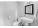 Clean, simple bathroom with pedestal sink, toilet, and framed mirror at 3402 E Sells Dr, Phoenix, AZ 85018