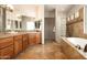 Luxurious main bathroom featuring double sinks, a glass block partition and a soaking tub at 35108 N 139Th Way, Scottsdale, AZ 85262
