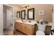 Bathroom with double sinks, decorative mirrors, and modern lighting fixtures at 4038 E Wrangler Ct, Gilbert, AZ 85297