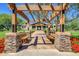 Stone pillar view to the community clubhouse featuring benches and lush landscaping at 4038 E Wrangler Ct, Gilbert, AZ 85297