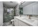 Bathroom features dual sinks, a large mirror, toilet and a luxurious walk-in shower at 4202 W Purdue Ave, Phoenix, AZ 85051