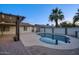 An outdoor pool area with a covered patio and manicured landscape, creating a private oasis at 4202 W Purdue Ave, Phoenix, AZ 85051