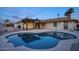A serene backyard featuring a freeform pool, covered patio, and lush landscaping, perfect for outdoor relaxation at 4202 W Purdue Ave, Phoenix, AZ 85051