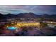 Twilight aerial showcasing mountain views, luxurious backyard, and a pool surrounded by lush landscaping at 4328 N Pinnacle Ridge Cir, Mesa, AZ 85207