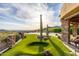 Expansive backyard view featuring lush green turf, desert flora, and a peek at the pool at 4328 N Pinnacle Ridge Cir, Mesa, AZ 85207