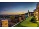 Expansive backyard with putting green, pool, fire pit, desert plants, and city views at 4328 N Pinnacle Ridge Cir, Mesa, AZ 85207