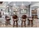 Custom home bar with stone accents, decorative lighting, and seating for four at 4328 N Pinnacle Ridge Cir, Mesa, AZ 85207