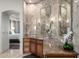 Bathroom vanity area with stone countertops, sconces, wood cabinets, and views into an adjoining bedroom at 4328 N Pinnacle Ridge Cir, Mesa, AZ 85207