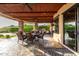 Spacious covered patio with a built-in grill, cozy seating, and views of the well-manicured backyard at 4328 N Pinnacle Ridge Cir, Mesa, AZ 85207