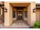 Beautiful entrance with custom iron doors and sidelights, accentuated by sconces, offers curb appeal at 4328 N Pinnacle Ridge Cir, Mesa, AZ 85207