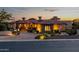 Charming home featuring stone accents, professional landscaping and a paver driveway at twilight at 4328 N Pinnacle Ridge Cir, Mesa, AZ 85207