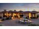 Beautiful home exterior showcasing a fountain, lush landscaping, and a paver driveway at twilight at 4328 N Pinnacle Ridge Cir, Mesa, AZ 85207