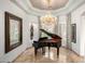 Bright living room with a grand piano, chandelier, and stylish window shutters at 4328 N Pinnacle Ridge Cir, Mesa, AZ 85207