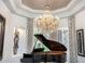 Stunning living room featuring a grand piano and a dazzling crystal chandelier at 4328 N Pinnacle Ridge Cir, Mesa, AZ 85207