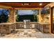 Fully equipped outdoor kitchen with stone accents, stainless steel appliances, and built-in grill at 4328 N Pinnacle Ridge Cir, Mesa, AZ 85207