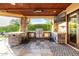 Well-equipped outdoor kitchen under a covered patio with a built-in grill, sink, and tiled flooring at 4328 N Pinnacle Ridge Cir, Mesa, AZ 85207