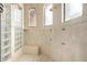 Bright walk-in shower featuring multiple shower heads, a tile bench, and glass block window at 4328 N Pinnacle Ridge Cir, Mesa, AZ 85207