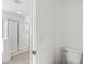 Bright bathroom featuring a glass-enclosed shower and neutral-toned tile flooring at 4404 W Ellis St, Laveen, AZ 85339
