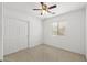 Well-lit bedroom with a ceiling fan, closet, and a window providing natural light at 4404 W Ellis St, Laveen, AZ 85339
