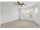 Well-lit bedroom featuring a ceiling fan, windows, and neutral carpet at 4404 W Ellis St, Laveen, AZ 85339