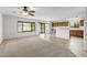 Living room showcasing neutral carpet and tile flooring, a ceiling fan, and seamlessly connecting to the kitchen at 4404 W Ellis St, Laveen, AZ 85339