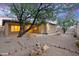 Backyard features desert landscaping, mature trees, accent lighting, and privacy at 4562 S Alamos Way, Gold Canyon, AZ 85118