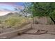 Backyard featuring desert landscaping, mature trees, wrought iron fence, and mountain views at 4562 S Alamos Way, Gold Canyon, AZ 85118