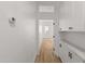 Bright hallway featuring wood floors and white cabinetry with updated hardware and an open doorway at 4562 S Alamos Way, Gold Canyon, AZ 85118