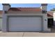 Attached two-car garage featuring a red tile roof and a white door at 4718 W Sanna St, Glendale, AZ 85302
